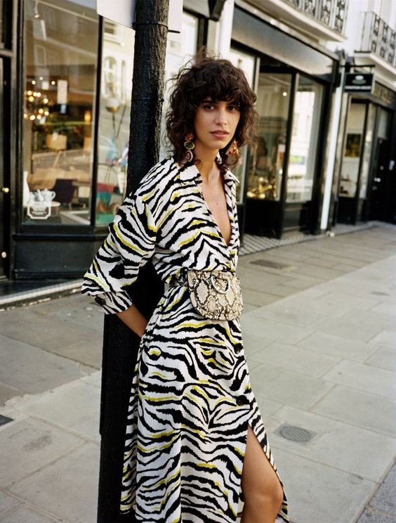 a girl standing and posing for the camera in zebra print . how to style zebra print for the perfect outfit inspo